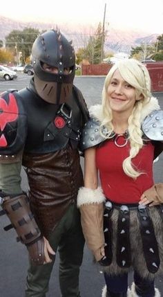 two people dressed up in costumes standing next to each other on a parking lot with cars behind them