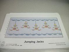 an old cross stitch pattern for jumping jacks on a white tablecloth with blue border