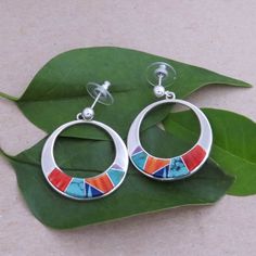 These Sterling Silver, Channel Inlay Hoop Earrings Were Handmade By Val Yazzie With Colorful Gemstones Of Turquoise, Red, Orange And Purple Spiny Oyster And Lapis Lazuli Set In Polished Sterling Silver. The Design Of These Post, Dangle Earrings Along With The Impeccable Craftsmanship Make A Memorable Impression! Signed: V Yazzie, Navajo Native American Artist Stamped: Sterling Post Dangle Earrings Measures: 1 3/4 1 1/4" Diameter Made In The Usa Free Domestic Shipping Modern Multicolor Dangle Jewelry, Multicolor Natural Stone Hoop Jewelry, Multicolor Natural Stones Hoop Jewelry, Multicolor Hoop Jewelry With Natural Stones, Modern Multicolor Hoop Jewelry, Modern Multicolor Small Hoop Jewelry, Colorful Gemstones, Turquoise Jewelry Native American, Native American Artists