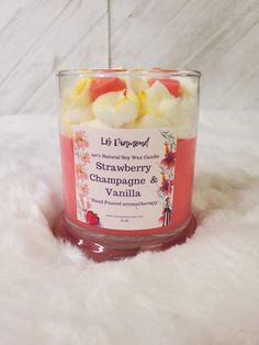 a candle that is sitting on a white fur covered floor next to a glass container filled with fruit