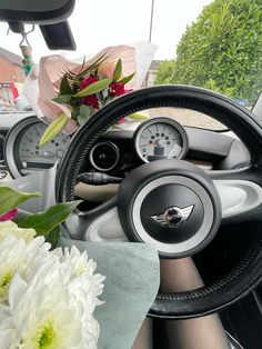 the interior of a car with flowers and steering wheel