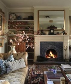 a living room filled with furniture and a fire place in the middle of it's fireplace