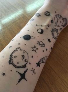 a person's arm with tattoos on it that have planets and stars all over them