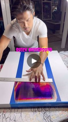 a person is cutting something with a large knife on a table that's covered in blue and pink paper