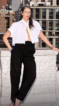 a woman standing on top of a roof with her hands on her hips