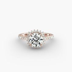 a rose gold engagement ring with an oval center stone surrounded by round brilliant cut diamonds