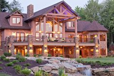 a large house with lots of windows next to a waterfall