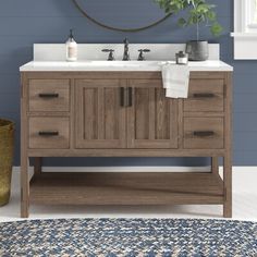 a bathroom vanity with two sinks and a mirror on the wall next to a rug