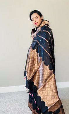 This stunning black 100% Mulberry Katan silk saree is handwoven in Banaras, known for its intricate designs and high-quality craftsmanship. The saree features a beautiful shade of black body and Meenadar flowers on the body with golden zari work, creating a mesmerizing effect. The body and palla has the kadbaan design depicting the pillars and corridors of the old historical palaces . The saree is perfect for any special occasion, such as a wedding, festival, or formal event. Comes finished with Black Silk Saree For Eid, Elegant Black Art Silk Dupatta, Elegant Black Saree For Transitional Season, Black Silk Dupatta With Traditional Drape, Black Silk Traditional Wear For Diwali, Black Silk Traditional Wear For Eid, Diwali Traditional Black Silk Wear, Elegant Black Art Silk Traditional Wear, Black Unstitched Silk Dupatta