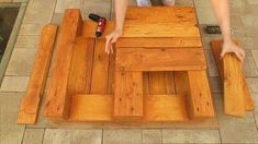 a person sitting at a table made out of pallet wood with one hand on it