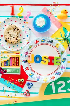 a table topped with lots of toys and paper plates covered in letters that spell out the word loose