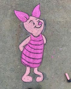 a drawing of a pink pig on the ground next to a pair of black shoes