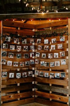 a wooden wall with pictures hanging on it and string lights strung from the ceiling above