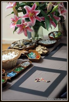 a table topped with lots of bowls filled with candy and flowers on top of it