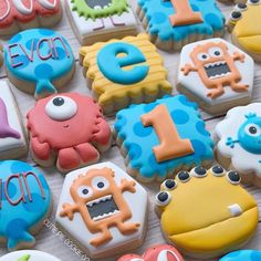 some decorated cookies with numbers and monsters on them for a first birthday or baby shower