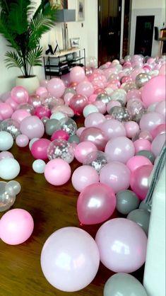 pink and grey balloons are scattered on the floor