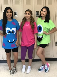 three girls standing next to each other in front of lockers with monster shirts on