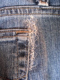 the back pocket of a pair of blue jeans with holes in it's side