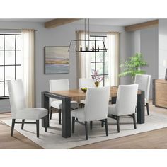 a dining room table with white chairs around it