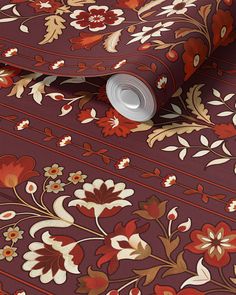 a red and brown floral wallpaper with an orange stripe on the bottom right corner