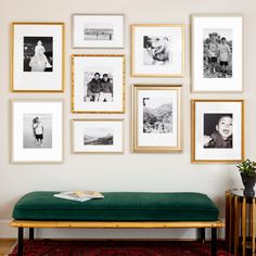 a green bench sitting in front of a wall filled with pictures