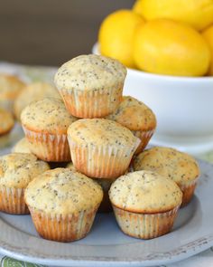 a pile of muffins sitting on top of a plate next to lemons