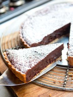 a chocolate cake on a cooling rack with one slice cut out and the other half eaten