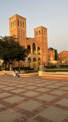 the large building has two towers on it's sides and is surrounded by brick steps