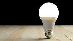 a light bulb sitting on top of a wooden table