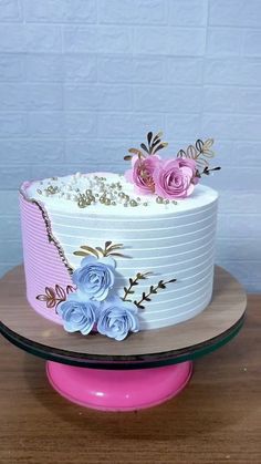 a white cake with pink and blue flowers on top