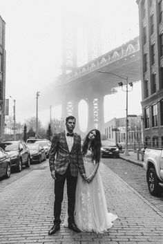 a man and woman standing in front of a bridge