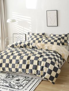 a black and white checkered comforter is on the floor next to a bed