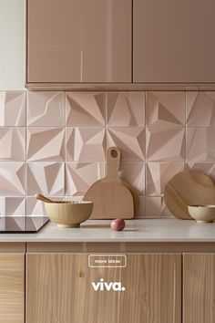 a kitchen counter with wooden bowls and cutting board on it, next to a pink tile backsplash