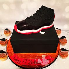 a birthday cake made to look like a shoe on top of a box with cupcakes around it