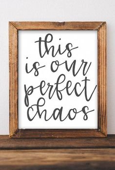 this is our perfect chaos sign in a wooden frame on top of a shelf with a white wall behind it