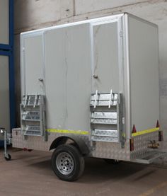 an enclosed trailer parked in front of a building