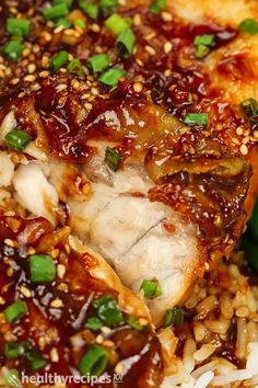 chicken with sauce and green peppers on top of rice