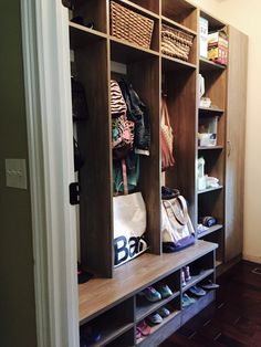 an open closet with shoes and bags on the shelves