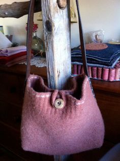 a pink purse hanging from a wooden pole