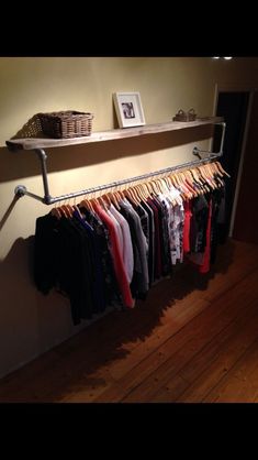 a rack with clothes hanging on it next to a wall