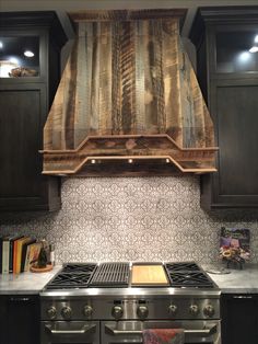 a stove top oven sitting inside of a kitchen next to dark wood cupboards and cabinets