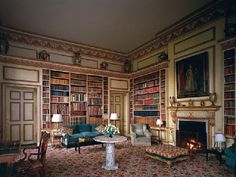 a living room filled with lots of furniture and bookshelves next to a fire place