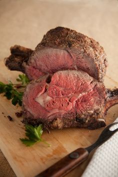 a piece of meat sitting on top of a wooden cutting board next to a knife