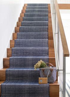 a blue carpeted stair case with a basket on it