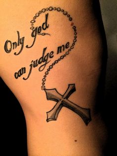 a tattoo with the words, only god can judge me and a cross on it