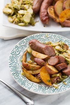 two plates with sausage and potatoes on them