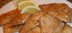 fried fish and lemon slices on a white plate