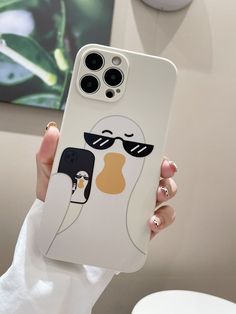 a person holding up a cell phone case with an image of a penguin wearing sunglasses