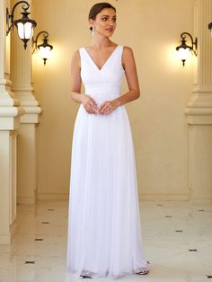 a woman wearing a white dress standing in a room