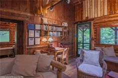 a living room filled with furniture and wooden walls